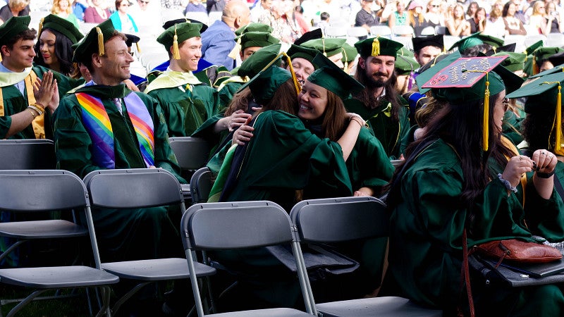ma/phd students embrace at ceremony