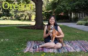 Woman holding her dog while sitting outside