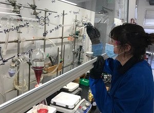 Researcher fills a vial with a liquid. 