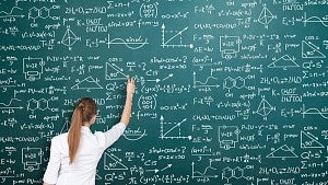 Woman doing scientific work on chalkboard.