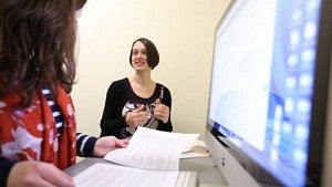 Students combining the use of digital and physical resources to study.