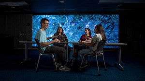 Students in front of a large screen in a multimedia lab at the UO