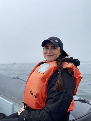 ENVS master's student Katie Russell on boat wearing orange lifejacket