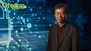Yingjiu Li standing in front of blue background