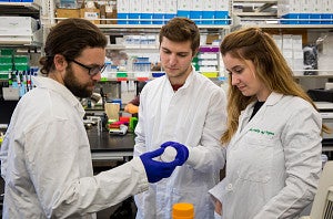 students in the knight campus internship program wearing lab coats in lab