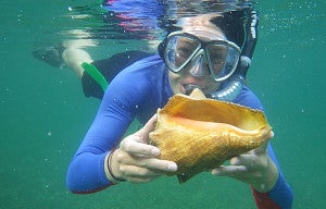 christina snorkeling and holding a conch shell