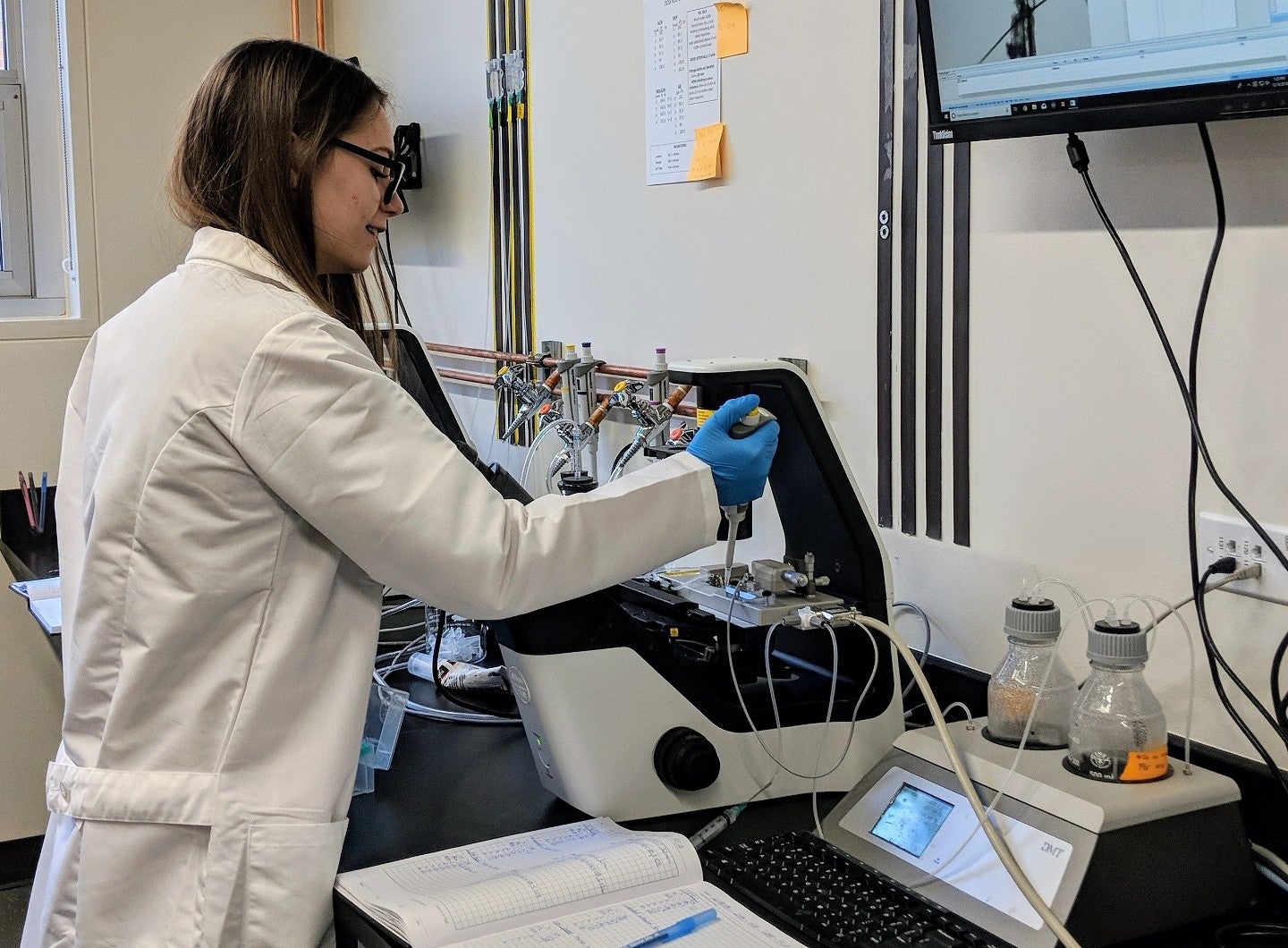A scientist fills a vial in a machine