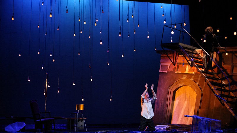 Man stands on stage and performs during a theatre play. 