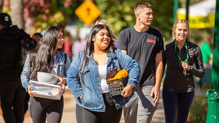 students walking and holding possessions during Unpack the quack day