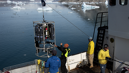 Researchers lift machine on boat