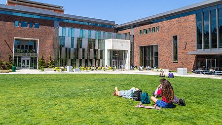 Students lay in the grass on the EMU lawn