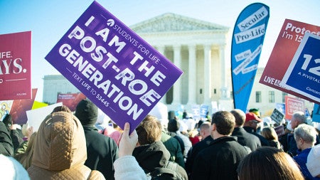  protester holds up a sign reading I am the post-roe generation 