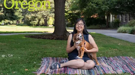 Kaori Idemaru sitting on the UO lawn holding a dog