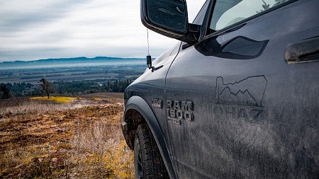truck door with OHAZ logo in the foreground and an oregon landscape in the background