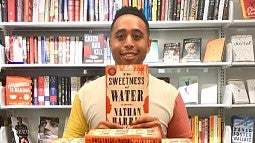 Nathan Harris holding up his book "Sweetness of Water"