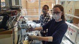 Doctoral students Lihaokun Chen (left) and Nicole Sagui assemble a bipolar membrane electrolyzer for testing.