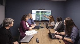 Researchers look at a map in a conference room. 