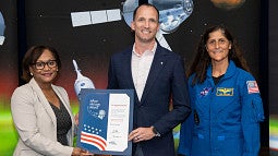 Dr. Steven Laurie at the Silver Snoopy award ceremony with Johnson Space Center Center Director Vanessa Wyche (left) and astronaut Suni Williams (right).
