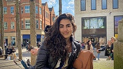 UO alumna Raimy Khalife-Hamdan poses in a crowded public square in winter.