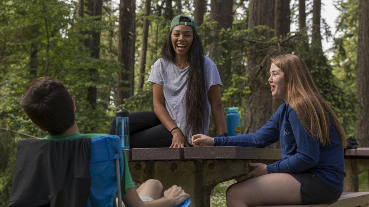 Students talking outdoors at picnic table
