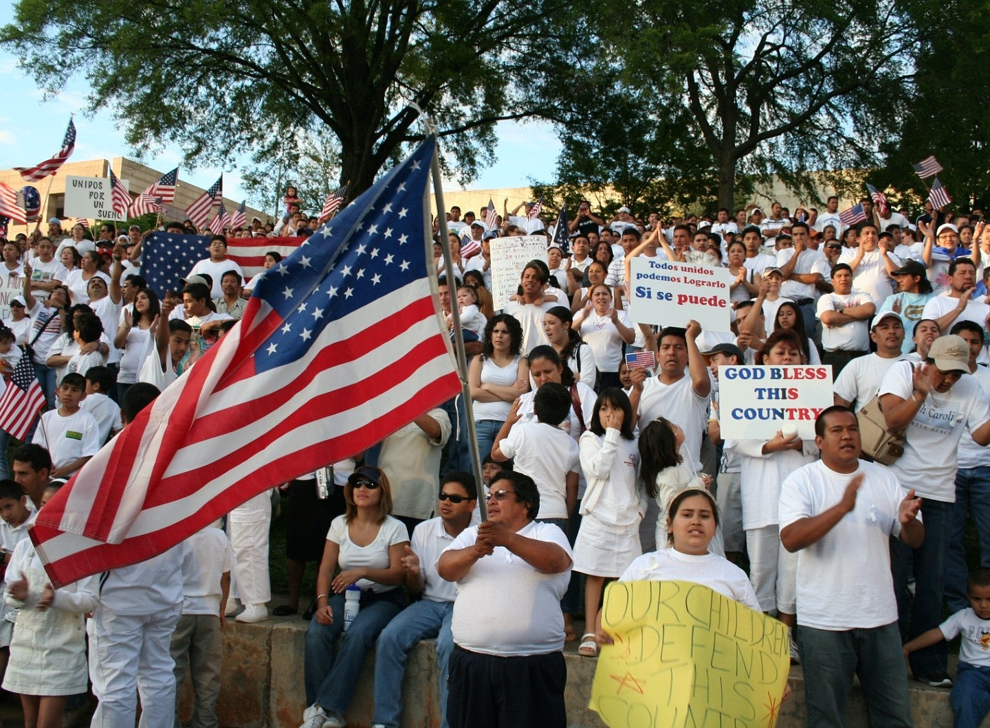 A crowd of protestors one of whom is holding the American flag. 