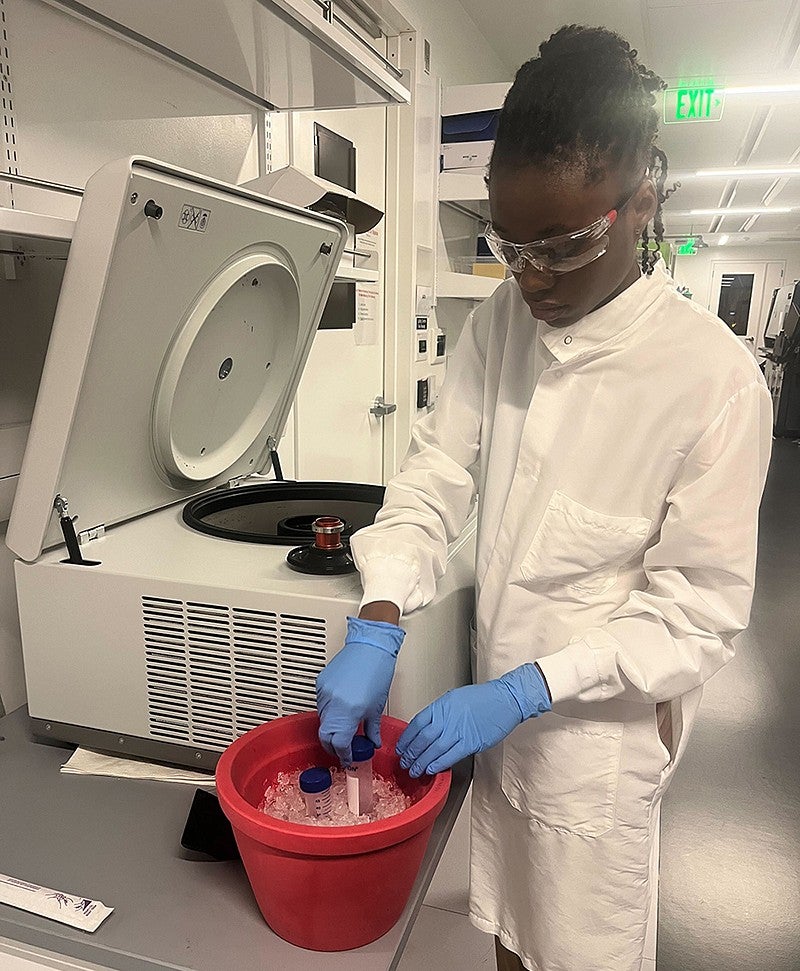 Student researcher working in a lab with equipment