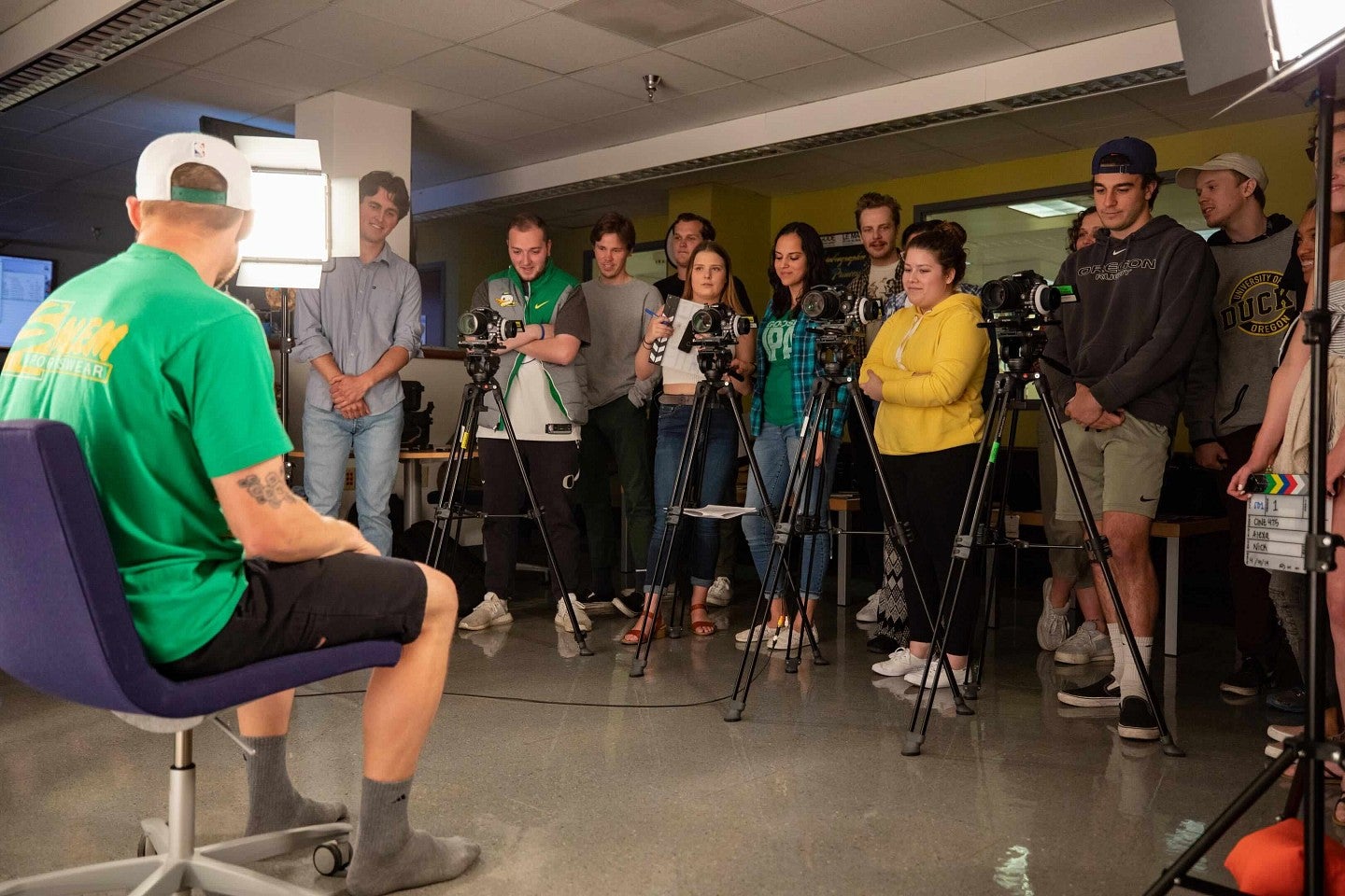 a group of students behind cameras with a person in front of a light