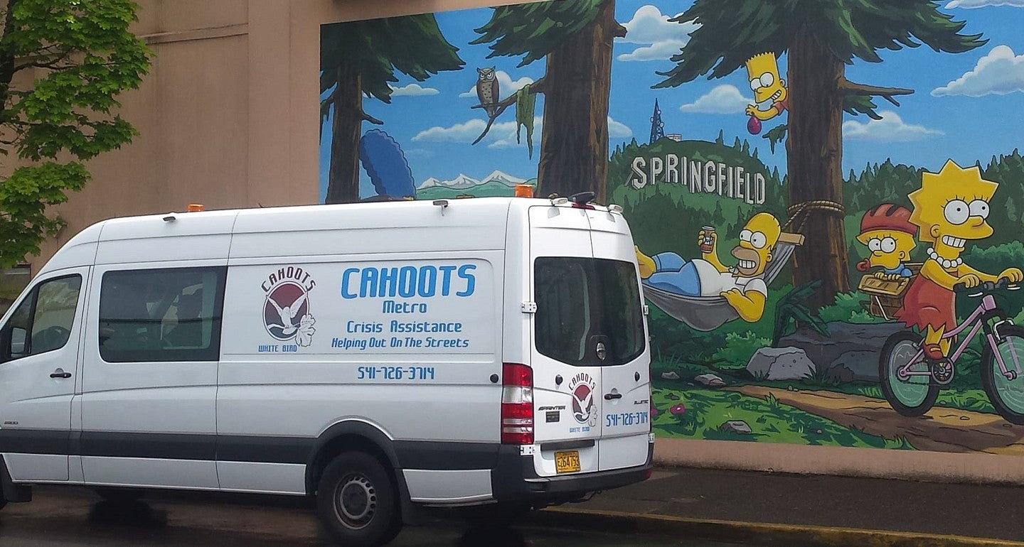 a white van in front of a simpsons mural