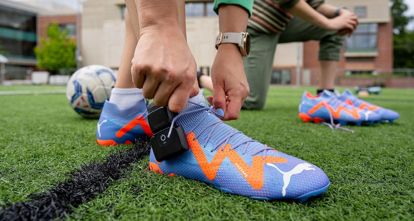 a woman ties her soccer shoes