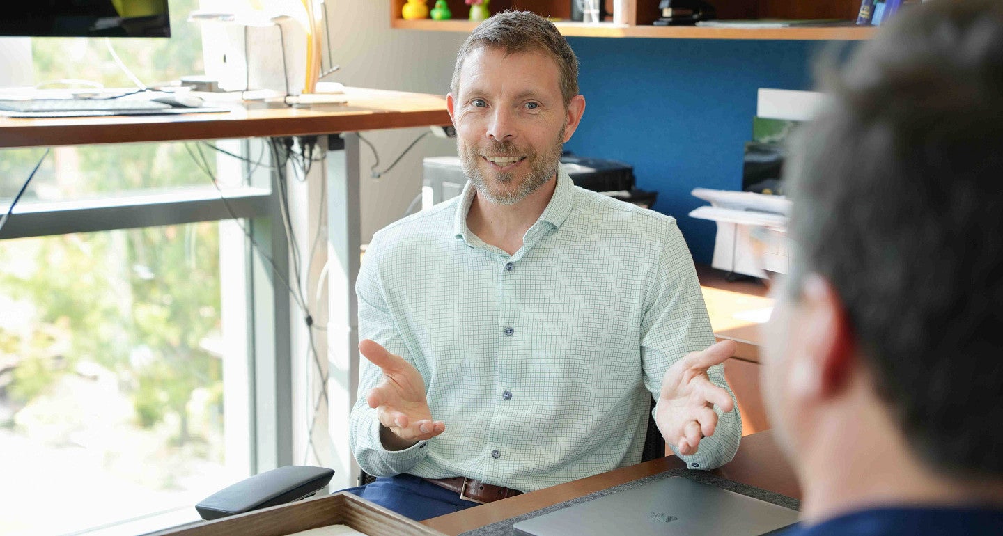 chris poulsen speaks to a person