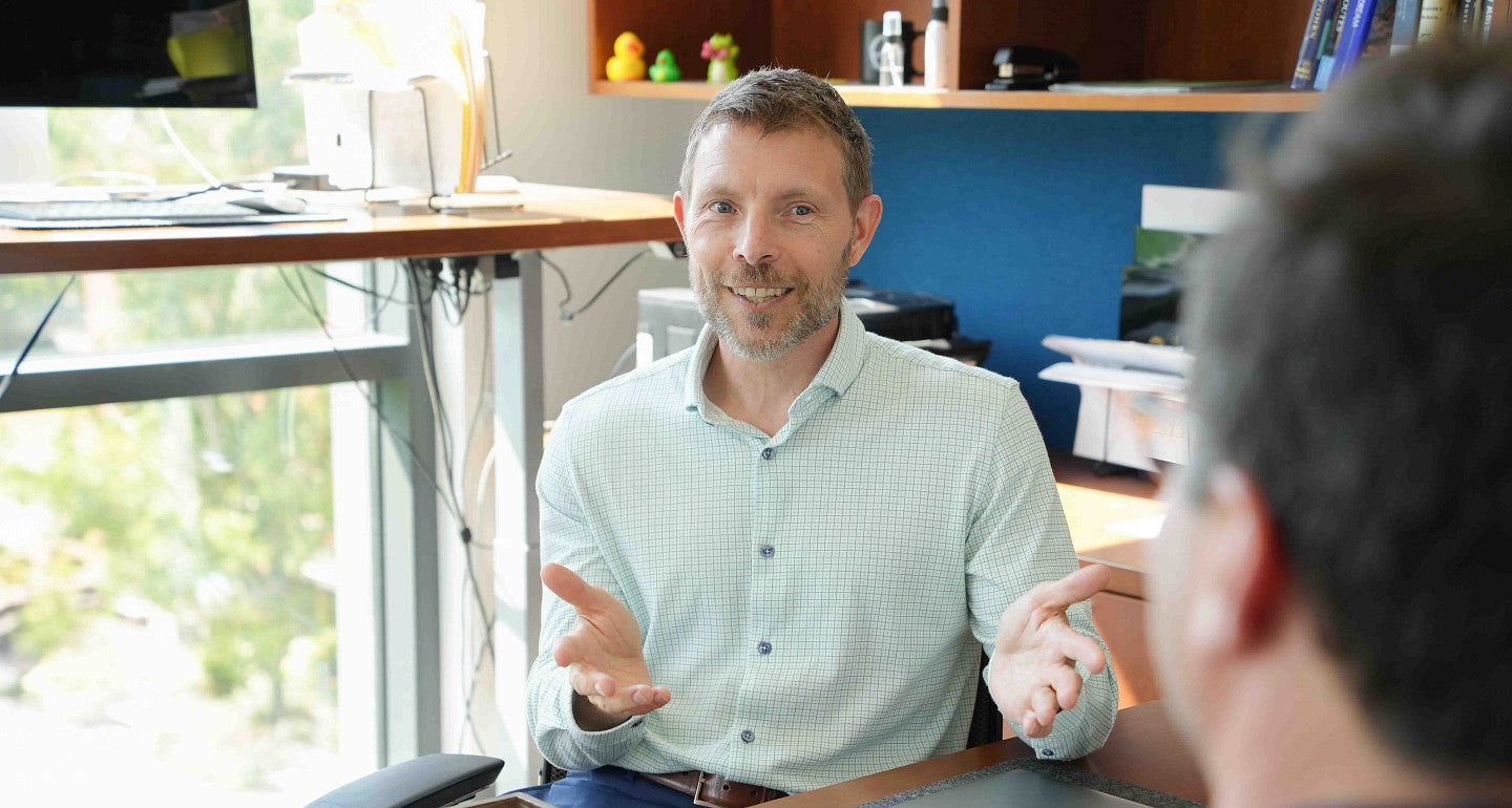 chris poulsen speaks to a person