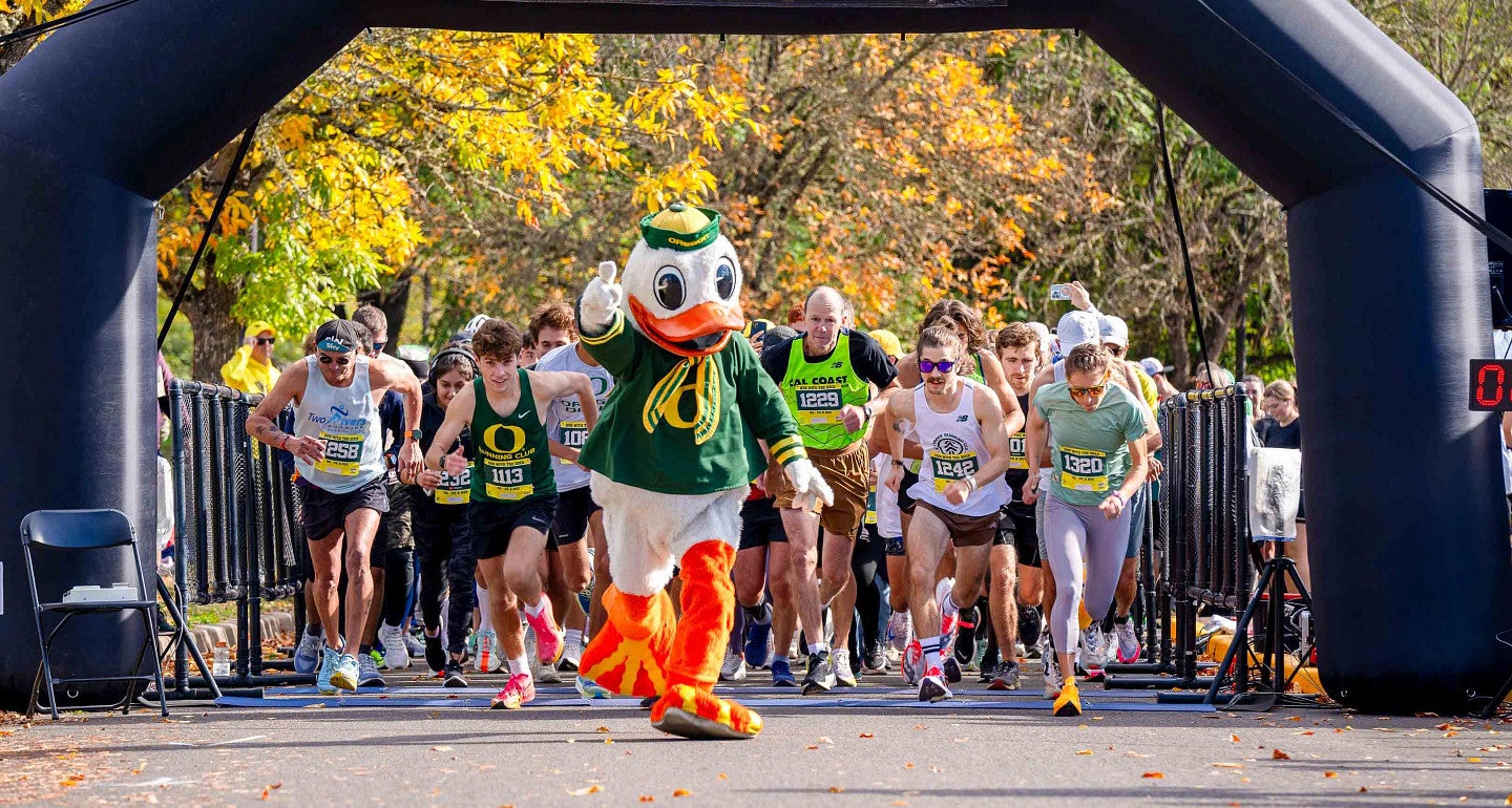 the oregon duck leads a group of runners