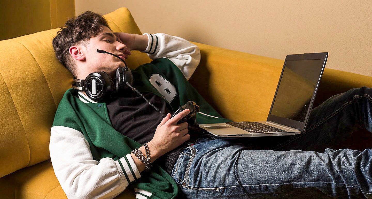 a person wearing a letterman's jacket sleeping on a couch