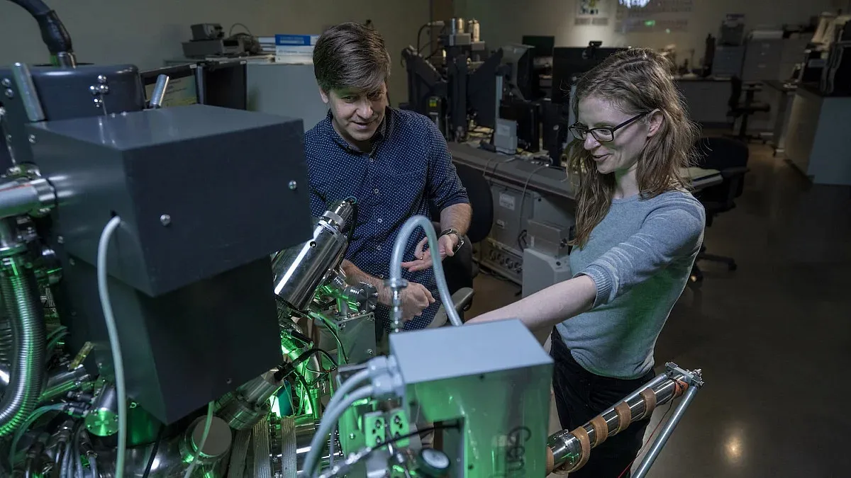 two people working in a lab beside a machine
