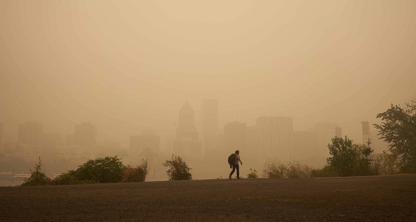 a person walking on a smoke filled horizon