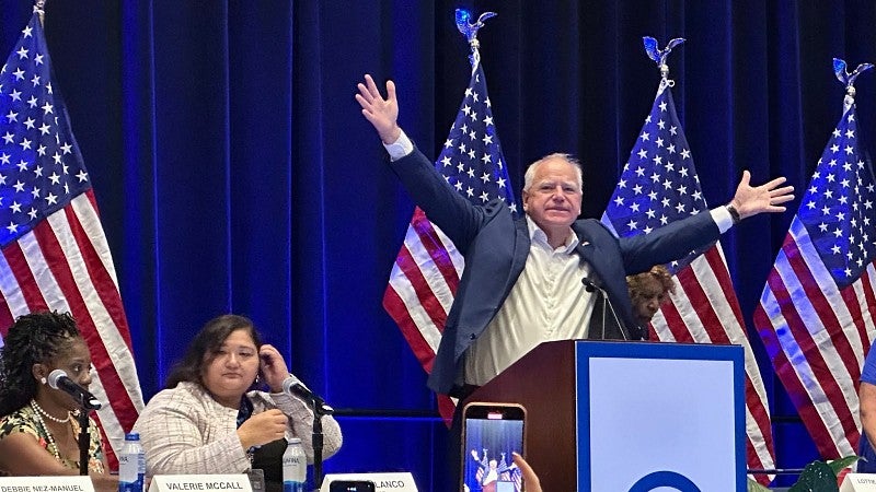 Minnesota Gov. Tim Walz extends his arms while speaking