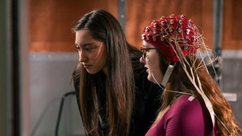 A researcher working with an person wearing an electrode cap