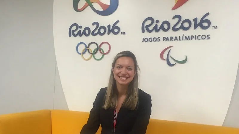 a person sitting in front of olympic logos