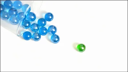 marbles representing particles spilling out on a flat surface
