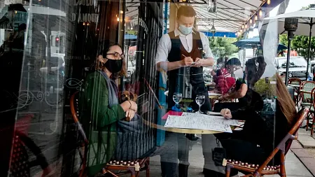 Diners and serving staff wearing face masks at a restaurant