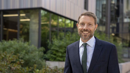 dean chris poulsen posing in front of Tykeson hall