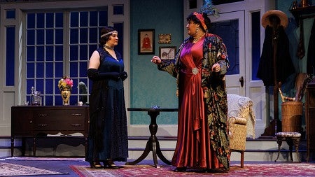 two people dressed in a 1920s era clothing on a theater stage