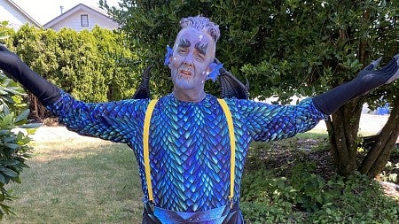 a person dressed up as a dragon for a theater production 