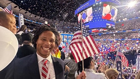 Chandler James holds a flag in an arena