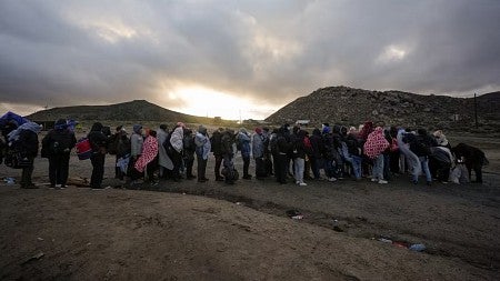 a line of immigrants in the American desert