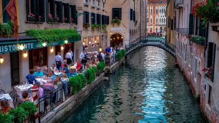 people eating near a canal in Italy