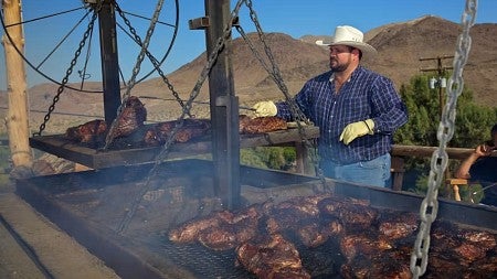 a man barbecues beef tri tip in the Mojave Desert