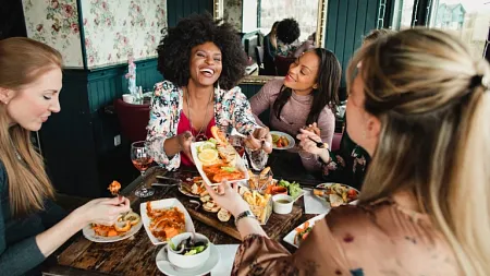 people sitting at a restaurant table, laughing