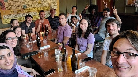 a group of people at a restaurant posing at a table for a photo