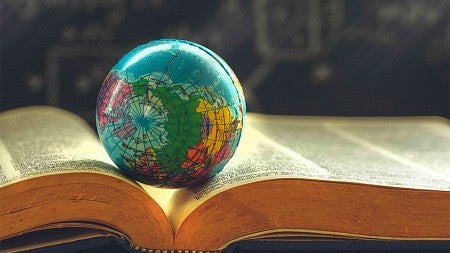 A miniature globe resting on top of an open book
